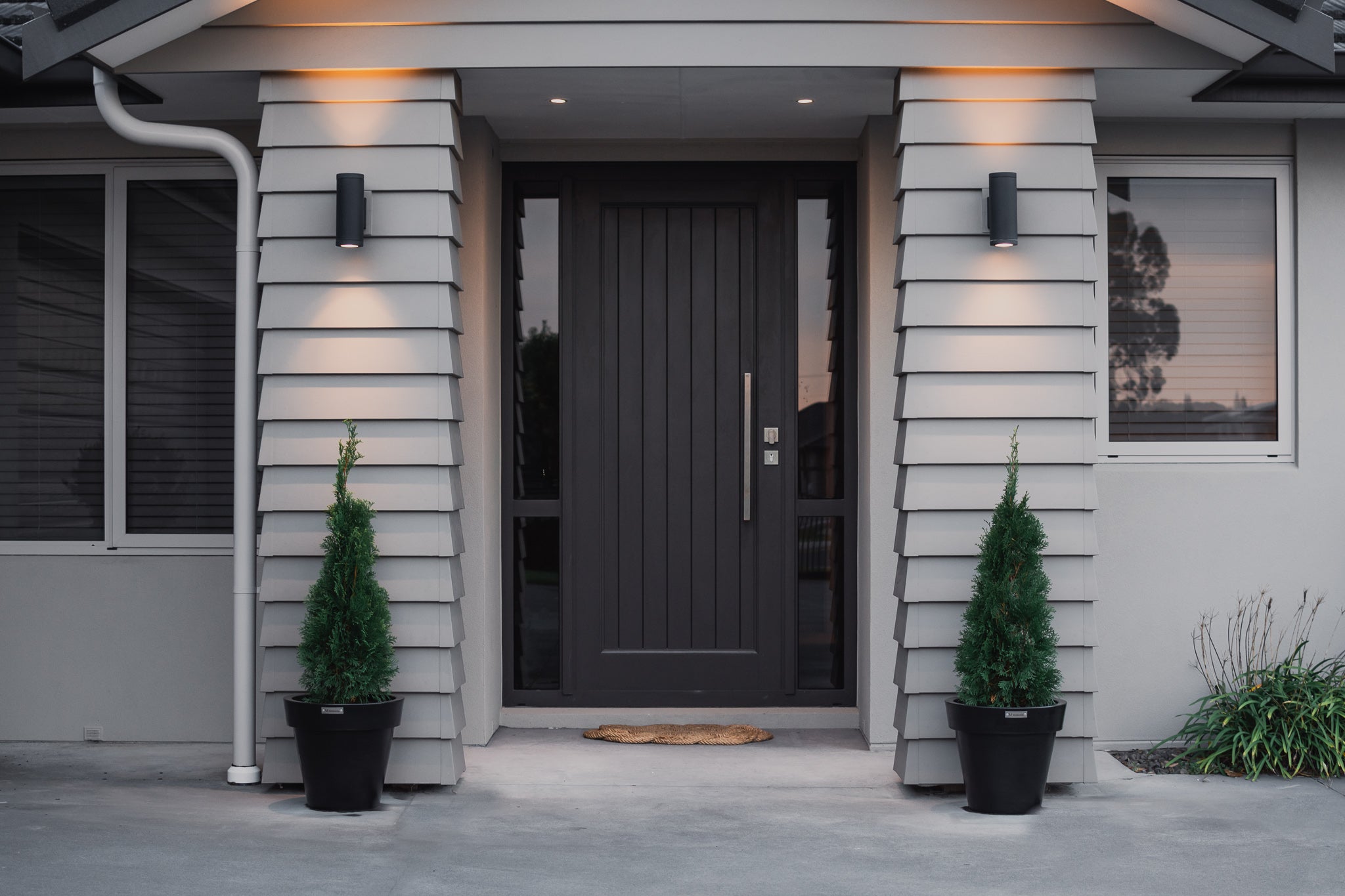 Modscene Madrid planters in front of a house planted with conifers. Black planter pots Australia.