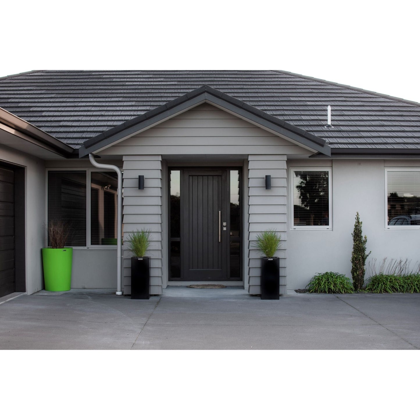 Two black Modscene planters either side of a house entrance way.