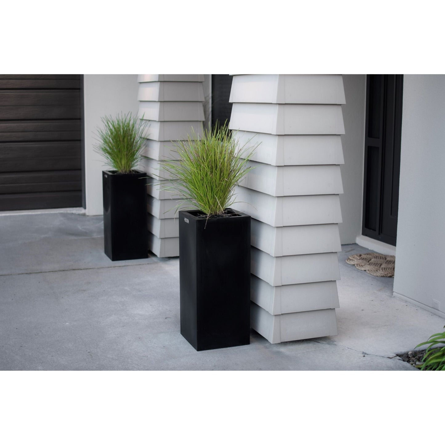 Cube planters in black planted with grasses.