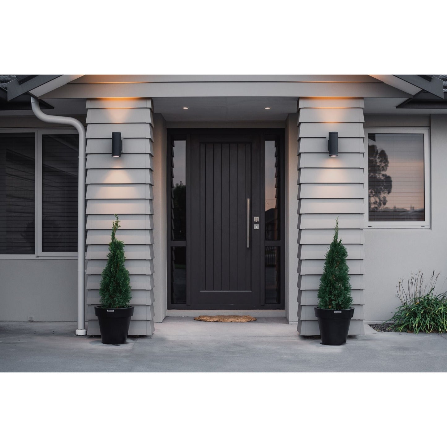 Small Modscene planters in front of house entrance. The planters are planted with small Conifers.