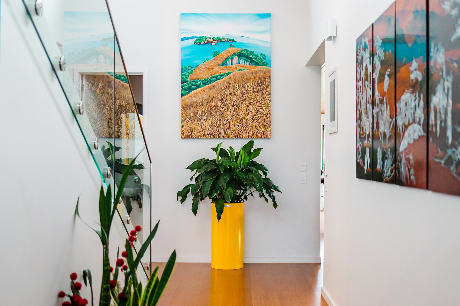 Yellow planter pot inside a home below a piece of artwork. Planter pots Australia.