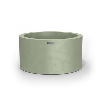 A medium sized planter pot in a pastel green colour with a concrete look finish.