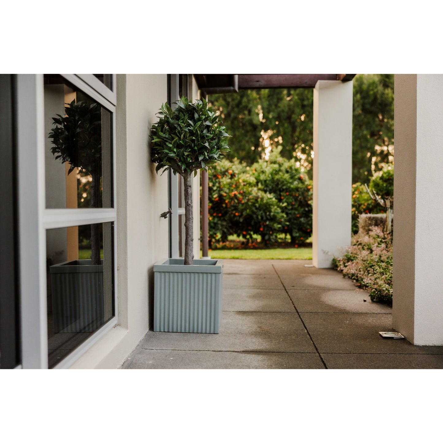 A corrugated square planter made by Modscene is a light grey colour.