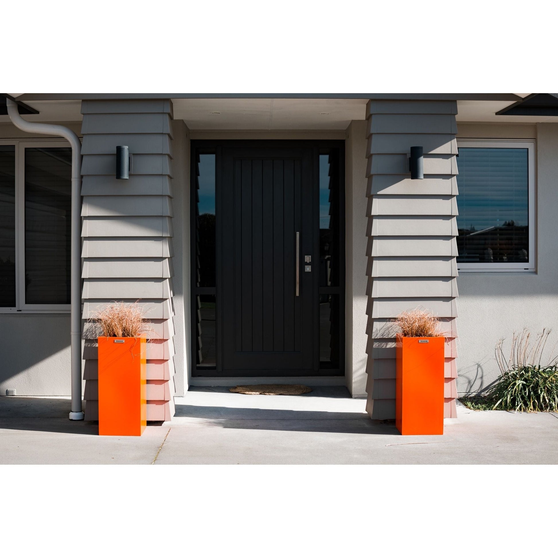 Two orange cube planters either side of a house entranceway. Modscene planters Australia.