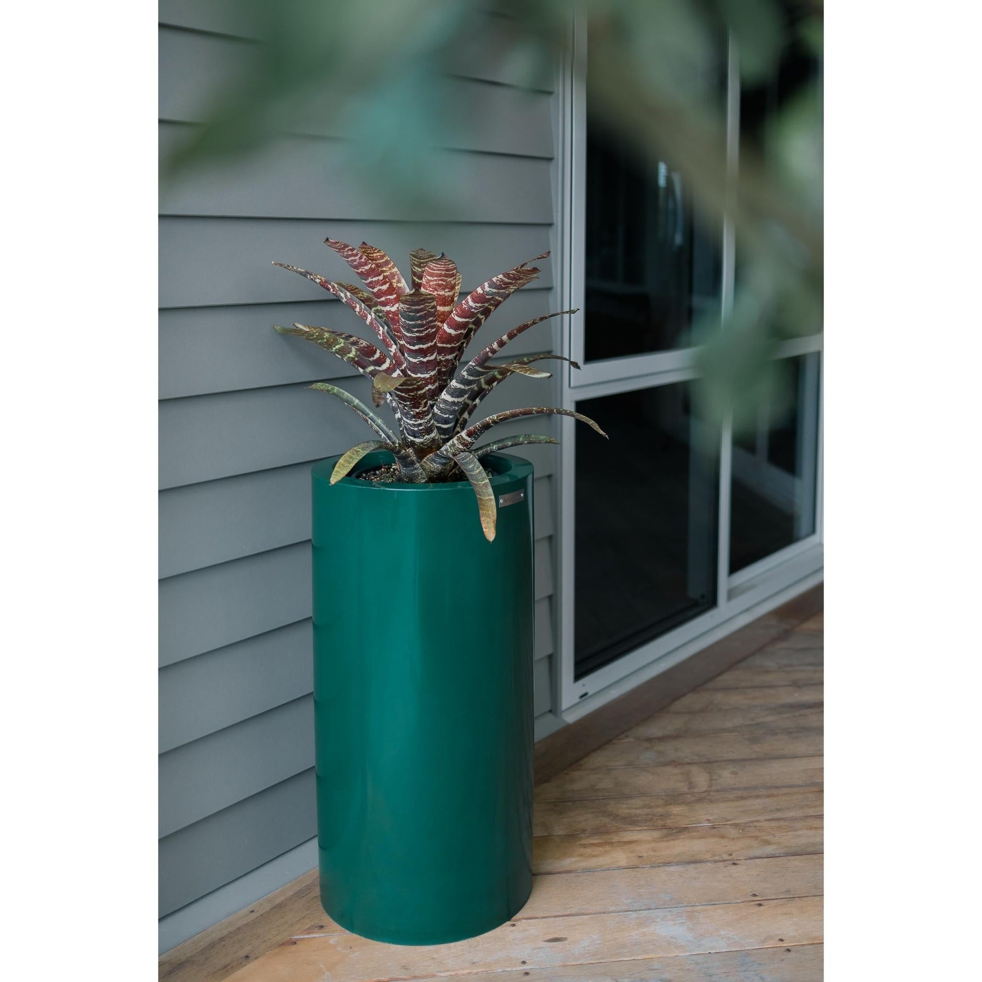 A Modscene cylinder planter in a emerald green colour.